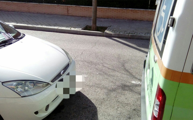 Coche aparcado cerca de una furgoneta para personas con discapacidad