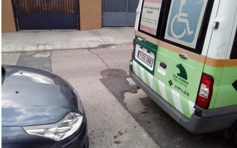 Coche mal aparcado detrás de una furgoneta para personas con discapacidad