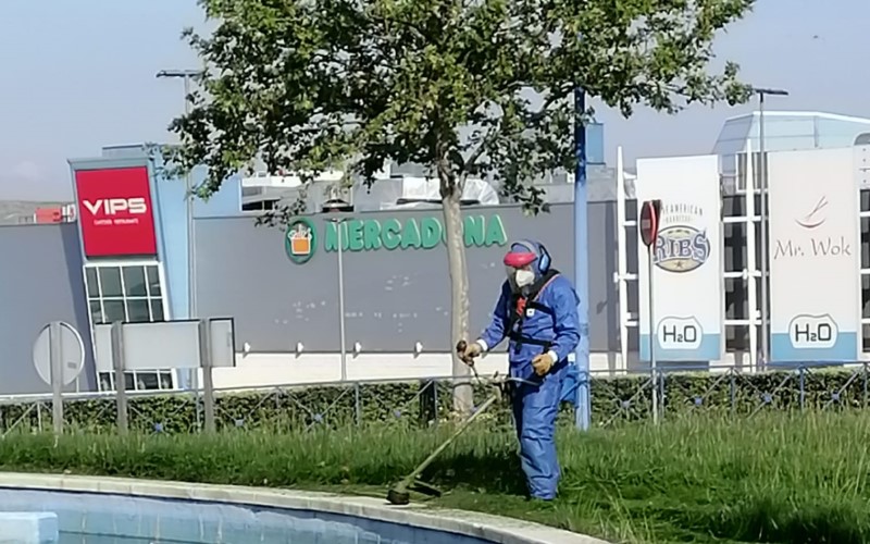 Un trabajador de Rivamadrid realiza tareas de jardinería frente al centro comercial H2O