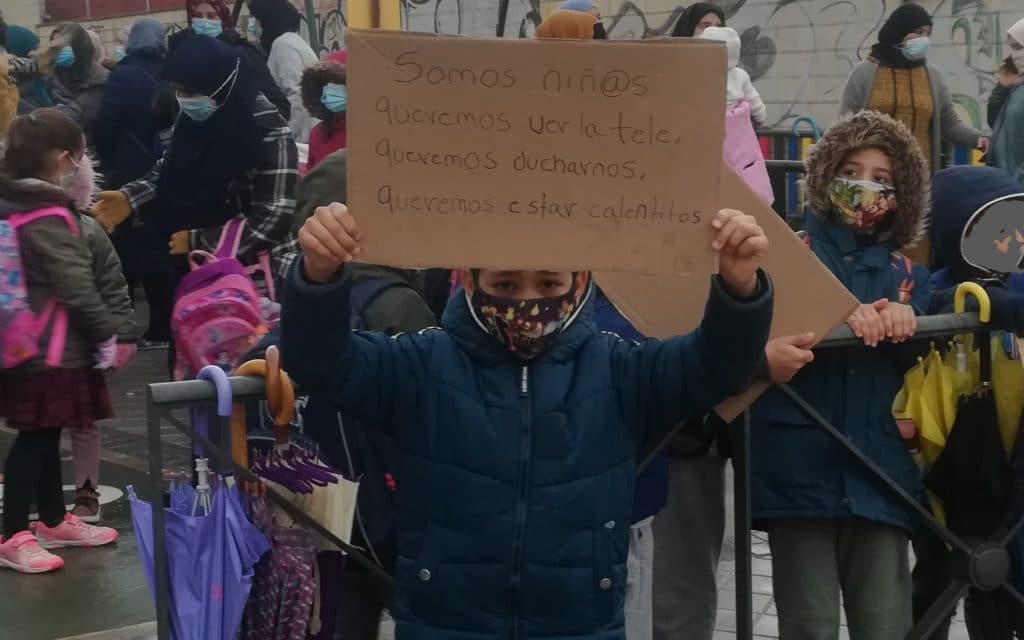 Un niño muestra un cartel en protesta por la falta de luz en la Cañada Real