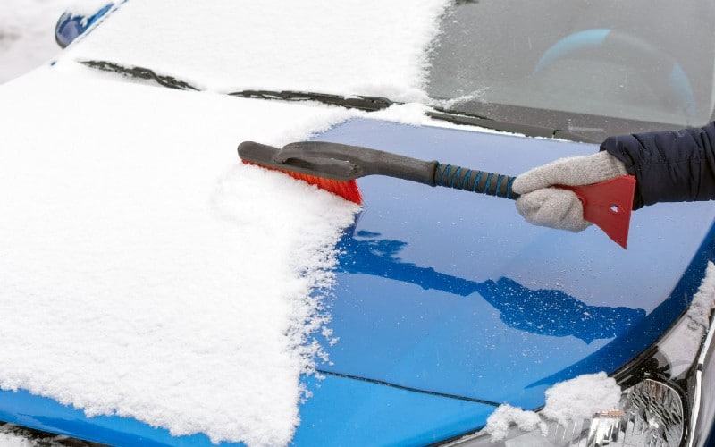 Cubrir el coche con una lona facilita la retirada de la nieve