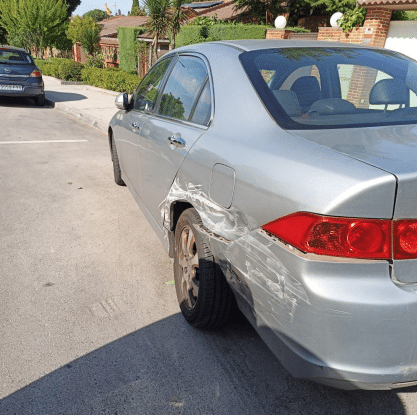 Daños en un coche estacionado por un accidente en la curva de la avenida de los Almendros (foto: PP Rivas)